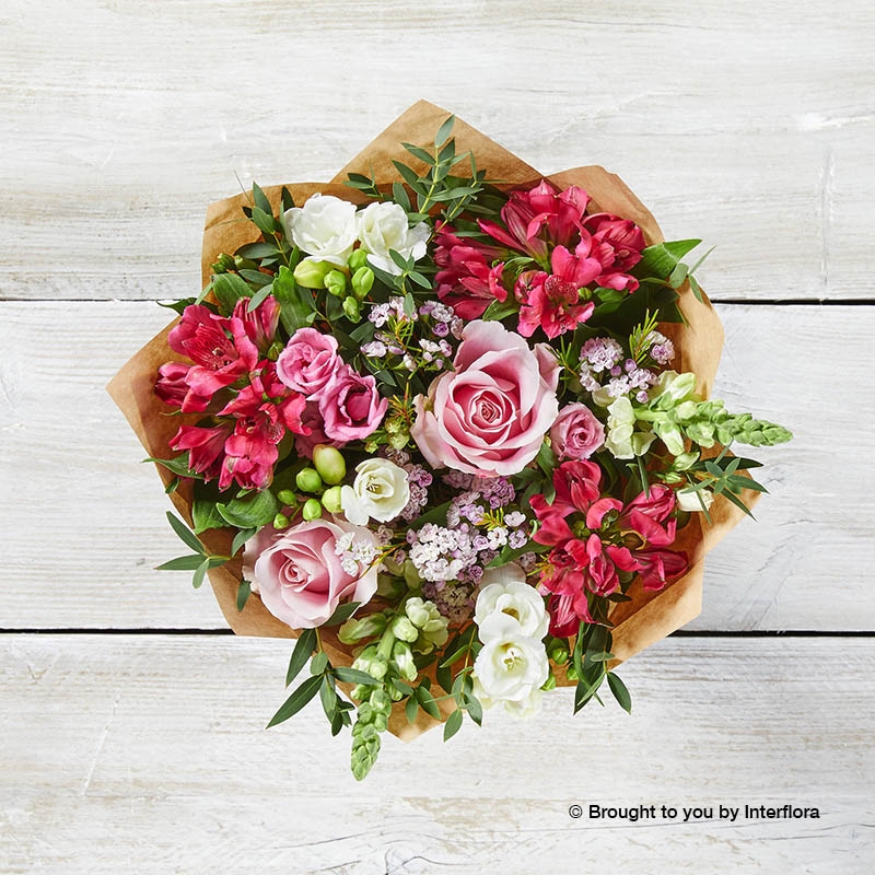 Cerise Alstromeria White Freesia Pink Lisianthus Pink Rose White Antirrhinum Pink Waxflower & greenery arranged in a lilac gift box