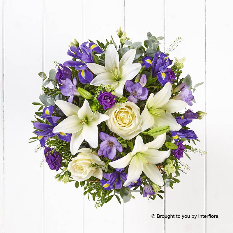 Purple Freesia Blue iris White Lily Purple Lisianthus Ivory Rose & greenery in a hand tied bouquet