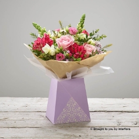 Cerise Alstromeria White Freesia Pink Lisianthus Pink Rose White Antirrhinum Pink Waxflower & greenery arranged in a lilac gift box