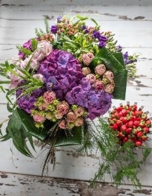 A selection of elegant flowers varieties including hydrangea and roses in shades of purple and lilacs.
