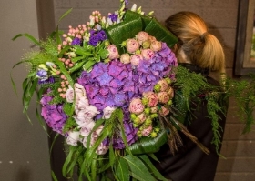 A selection of elegant flowers varieties including hydrangea and roses in shades of purple and lilacs.