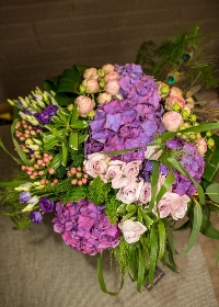 A selection of elegant flowers varieties including hydrangea and roses in shades of purple and lilacs.
